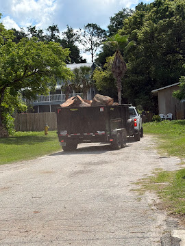 Dump trailer hauling away tree debris from a residential job